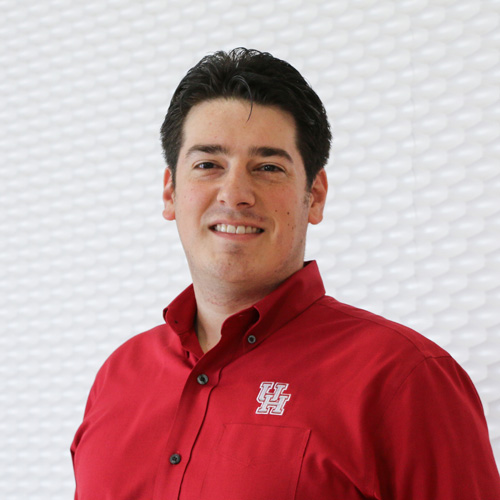 Portrait of a white man smiling wearing a red button-up shirt