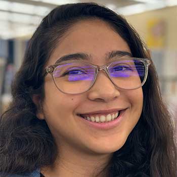Portrait of a Hispanic woman wearing glasses with long hair