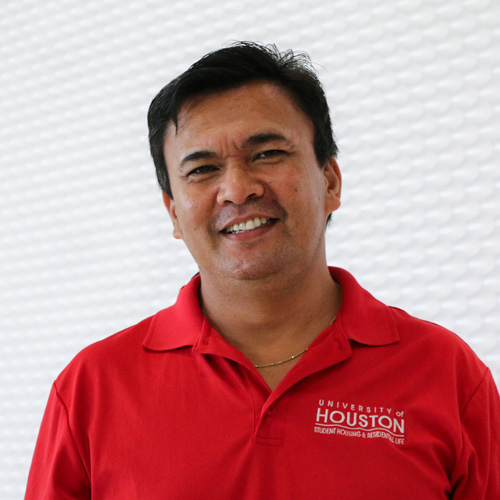 Portrait of an southeast Asian man smiling wearing a red polo shirt