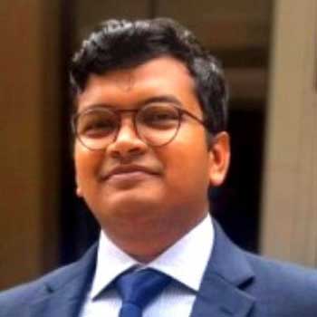 Portrait of an Indian man with glasses wearing a suit