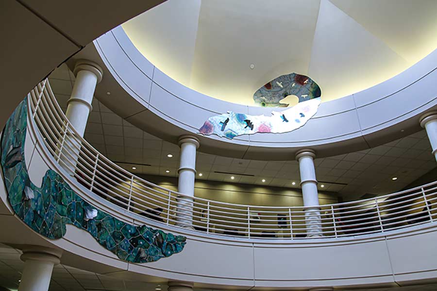 Metallic panels trace the walls between the floors of an interior rotunda