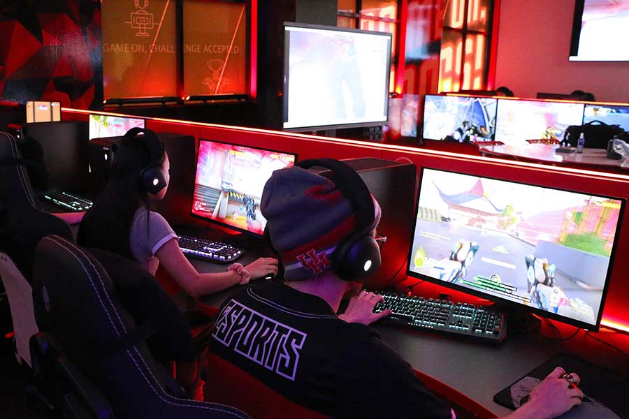 Members of the Coog Esports team sit at gaming stations playing.