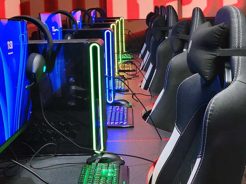 Close up of a row of high-end gaming computers with neon lighting.