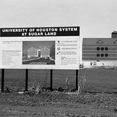 Construction sign in the foreground with a bulding in the background